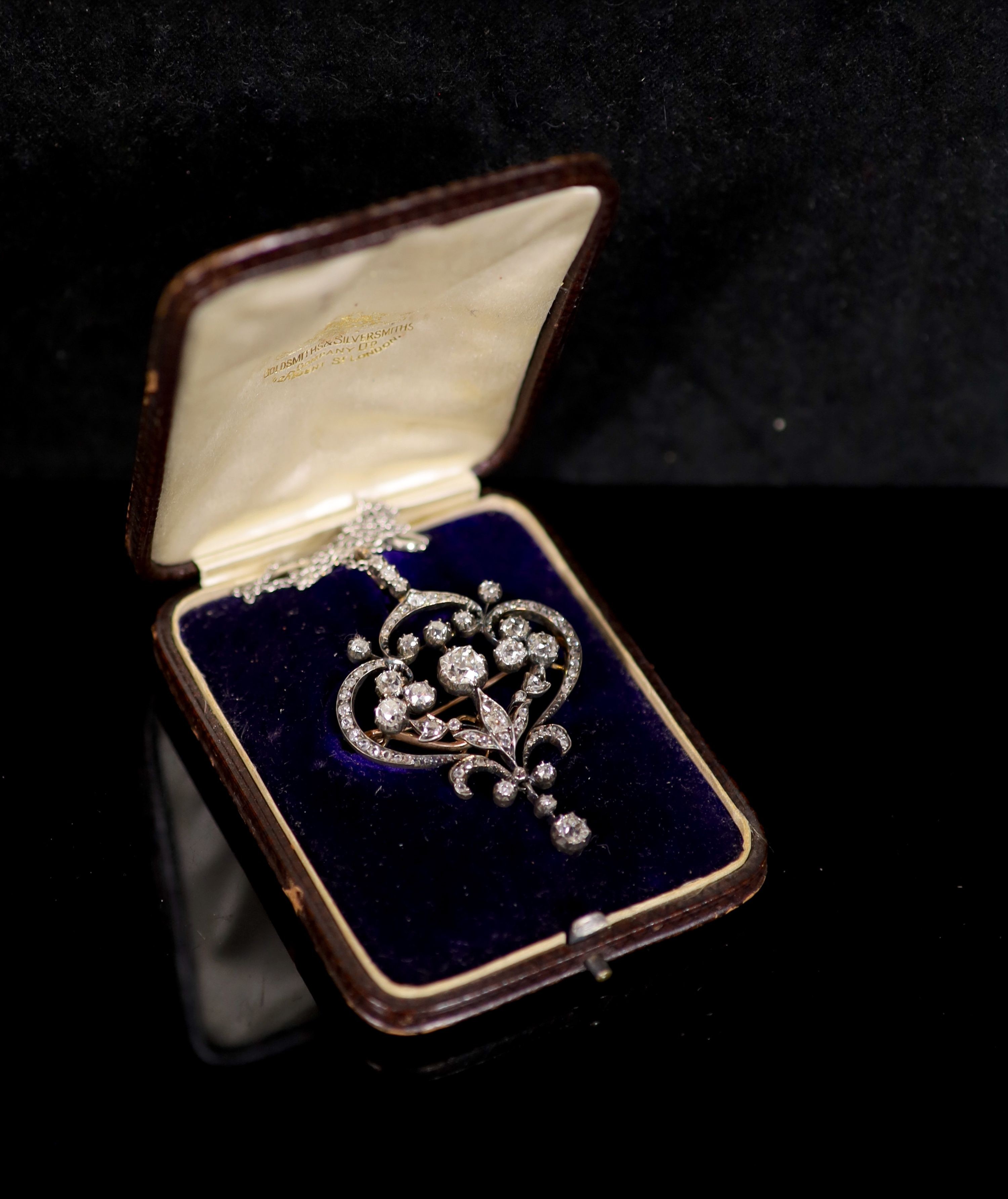 A 19th century gold, silver and diamond set open work scroll drop pendant brooch, together with a white metal chain